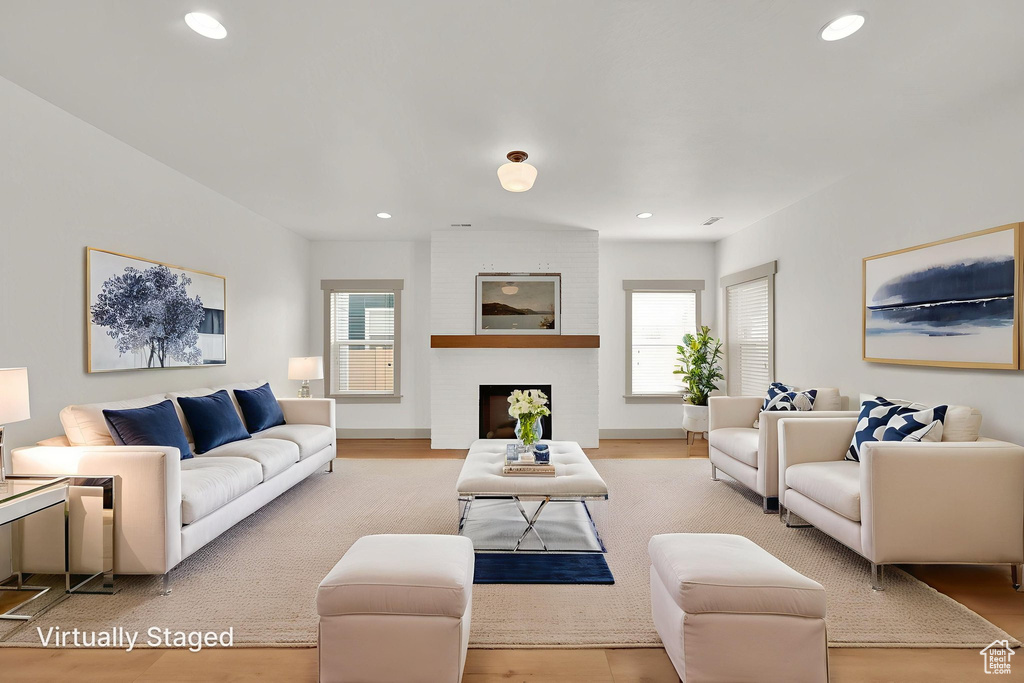 Living room with plenty of natural light, wood finished floors, and recessed lighting