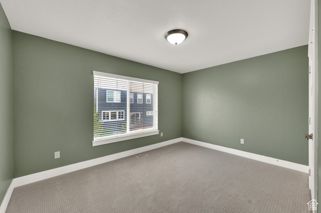 Carpeted spare room with baseboards