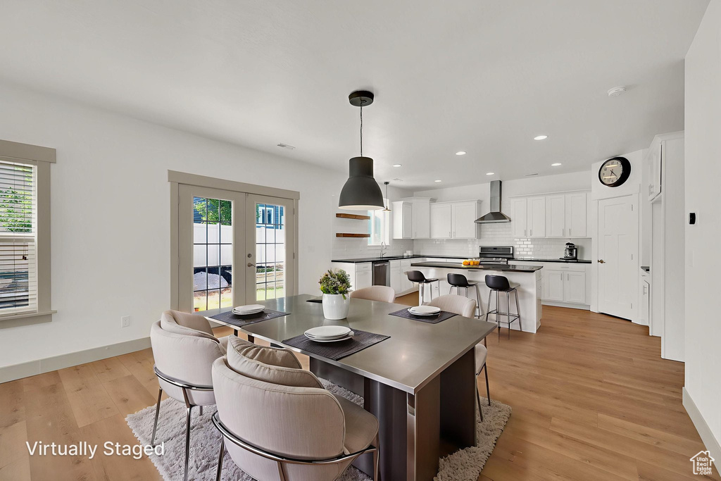 Dining space featuring french doors, light wood finished floors, and recessed lighting