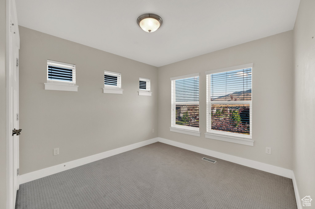 Empty room featuring carpet and baseboards