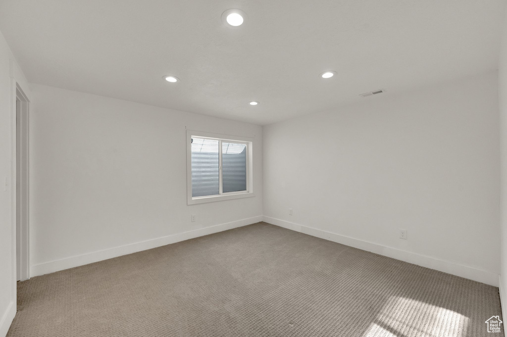 Empty room with carpet flooring and recessed lighting
