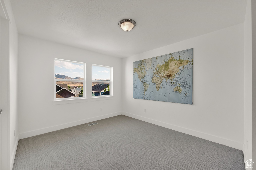 Carpeted empty room with baseboards