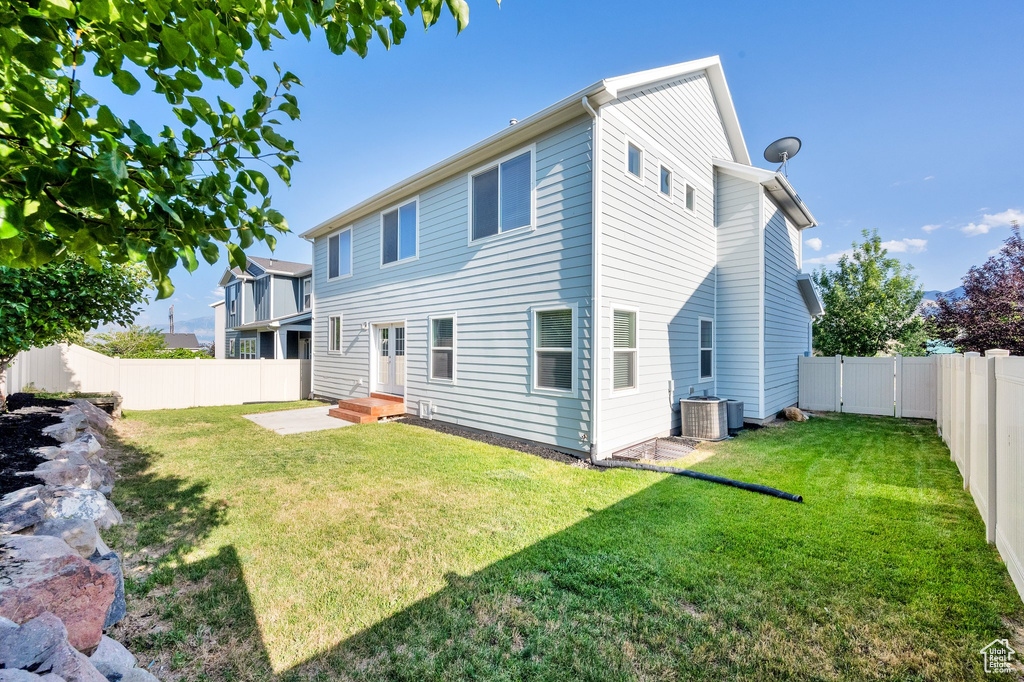 Rear view of property with a fenced backyard and entry steps