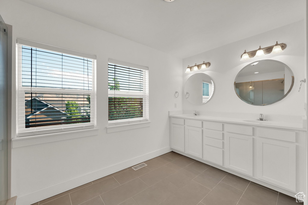 Bathroom with double vanity and tile patterned flooring