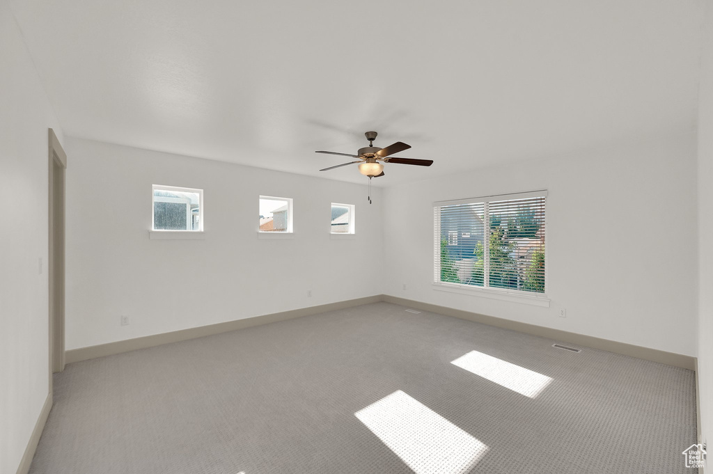 Spare room featuring light colored carpet and ceiling fan