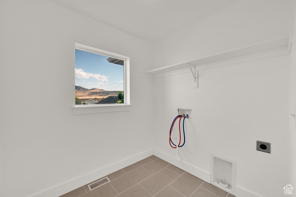 Washroom with washer hookup, gas dryer hookup, hookup for an electric dryer, and tile patterned flooring