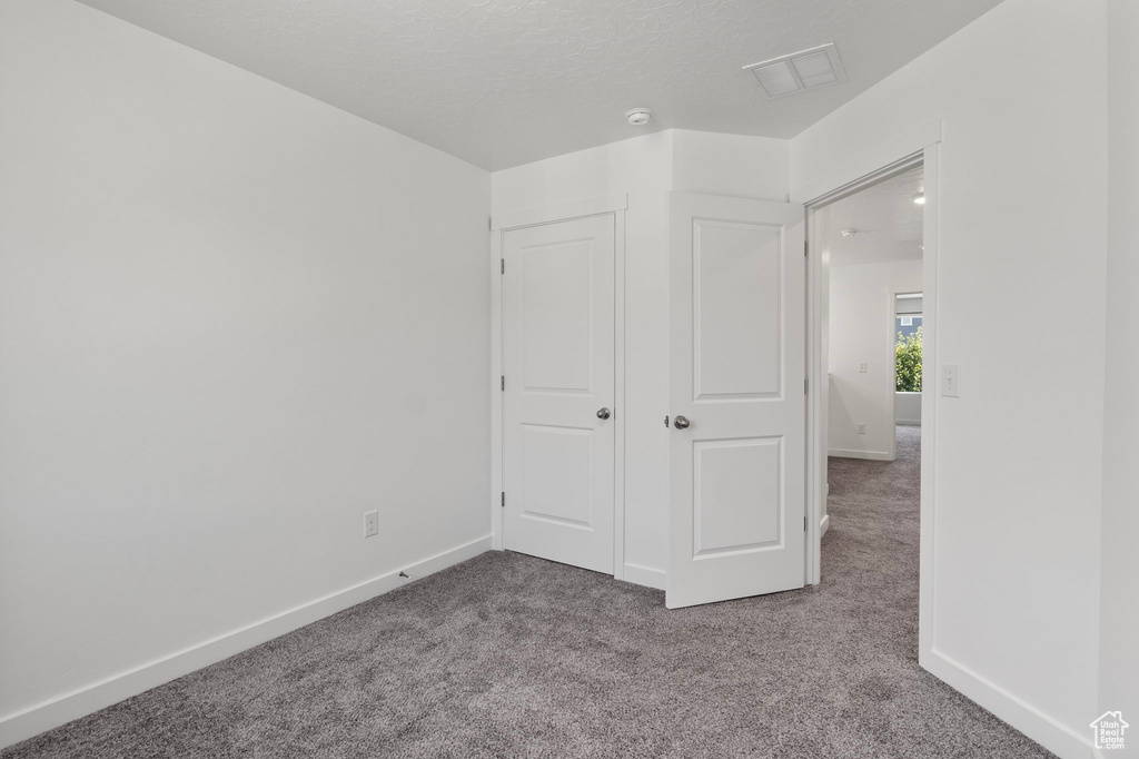 Unfurnished bedroom featuring carpet floors and baseboards
