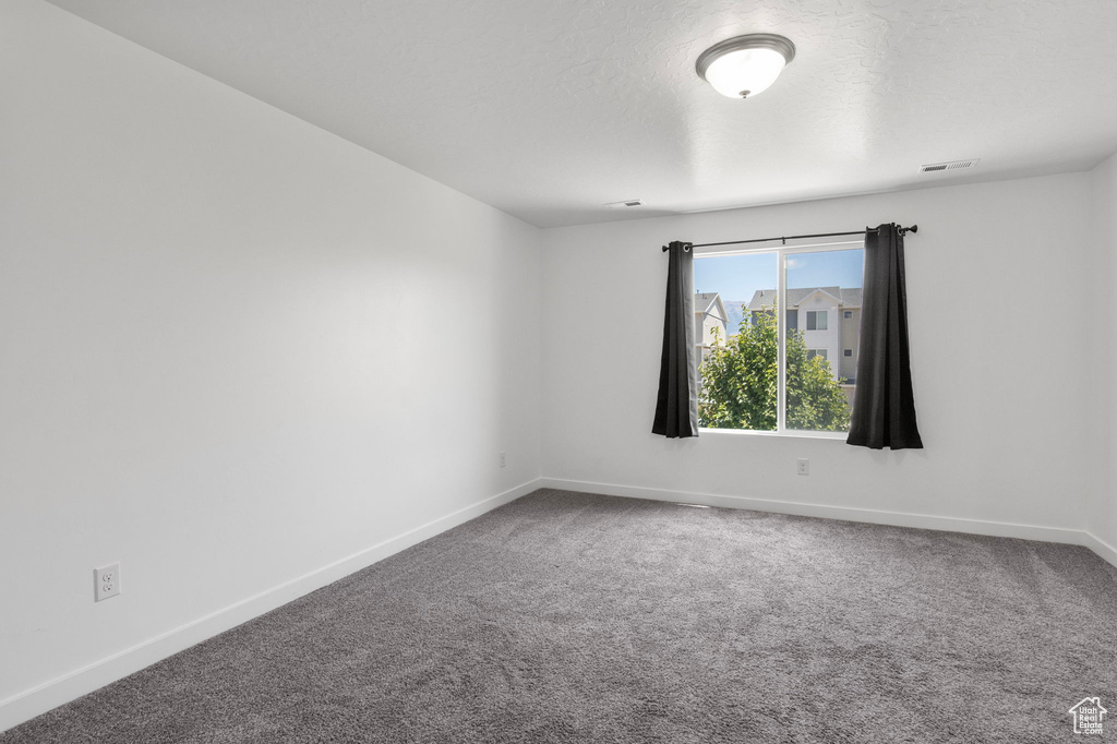 Spare room with carpet and baseboards