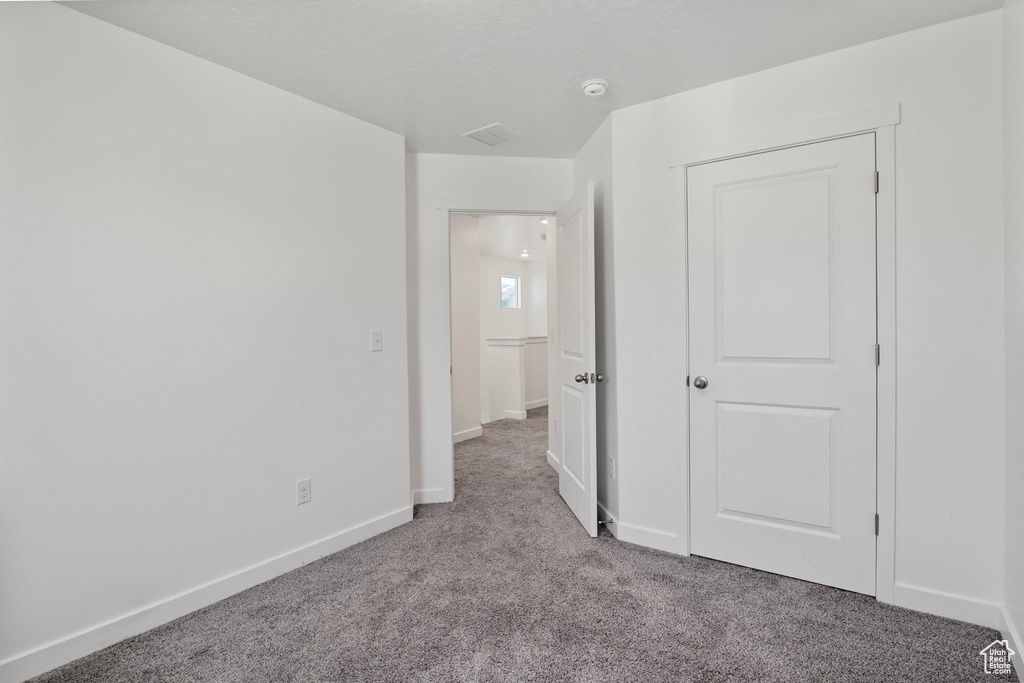 Unfurnished bedroom with carpet and baseboards