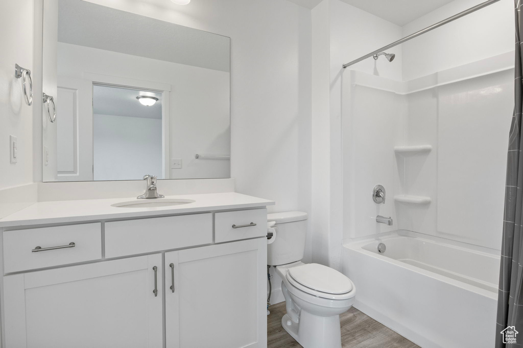 Bathroom featuring vanity, wood finished floors, and shower / bath combination