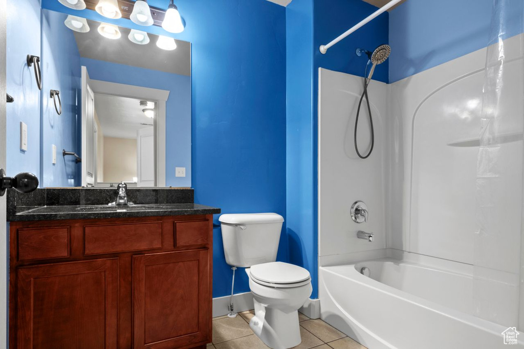 Bathroom with tile patterned flooring, washtub / shower combination, and vanity