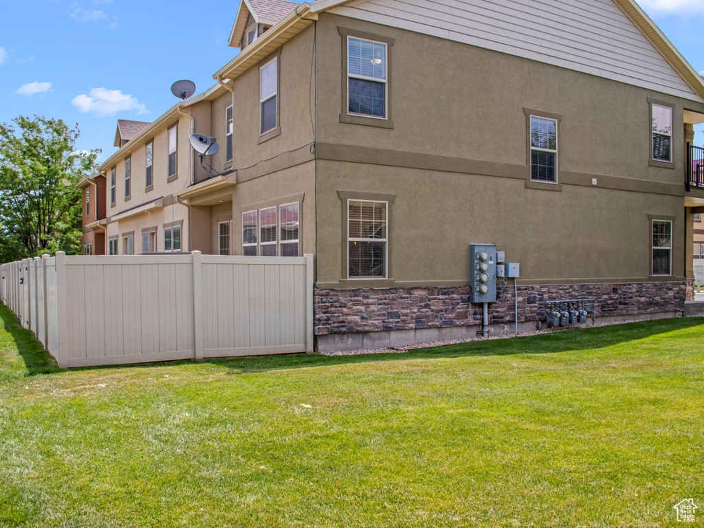 Rear view of house featuring stone siding and stucco siding