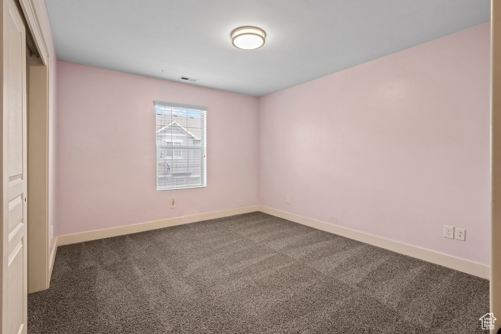 Carpeted empty room with baseboards