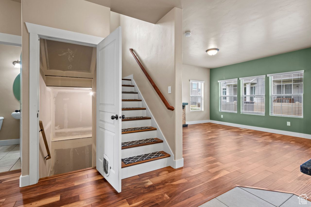 Stairs with wood finished floors and baseboards