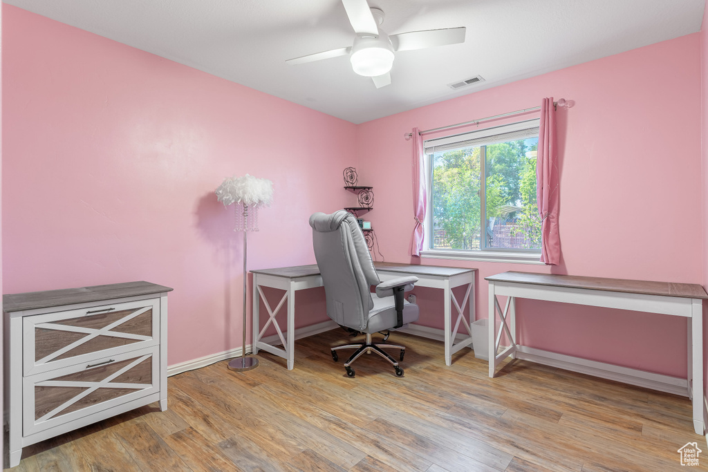 Office space with wood finished floors and a ceiling fan
