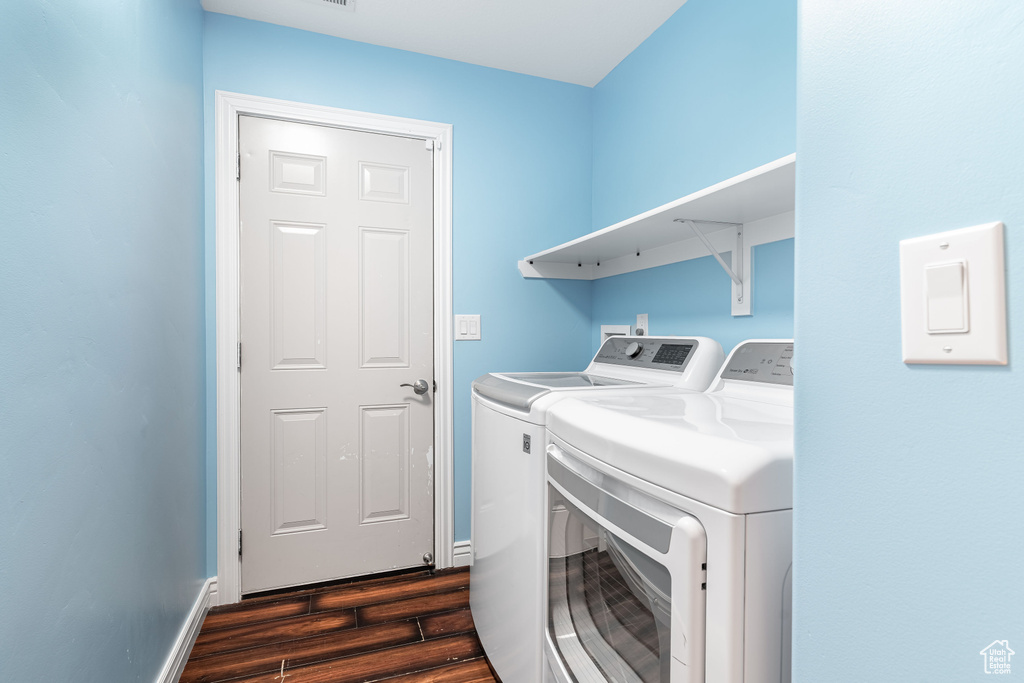 Washroom featuring washing machine and clothes dryer and dark wood-type flooring