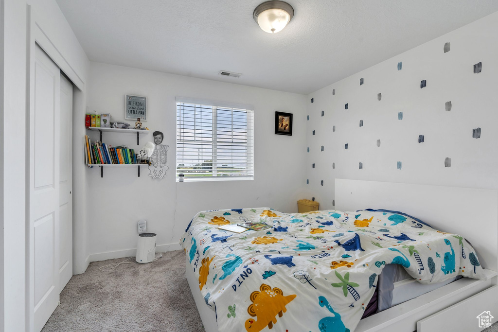 Bedroom featuring a closet and light colored carpet
