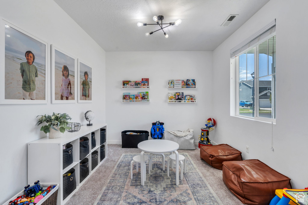Playroom with a chandelier and carpet floors