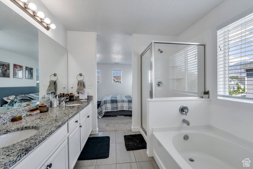 Bathroom featuring ensuite bathroom, double vanity, a shower stall, a garden tub, and tile patterned floors
