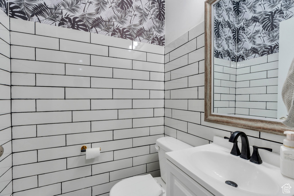 Bathroom featuring tile walls and vanity