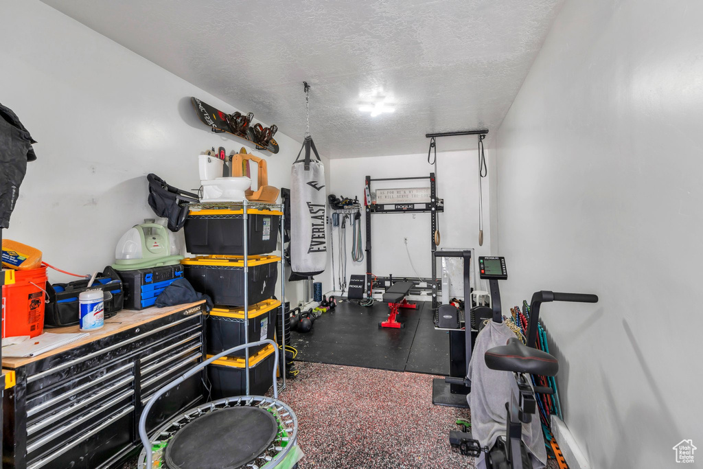 Exercise room featuring a garage and a textured ceiling