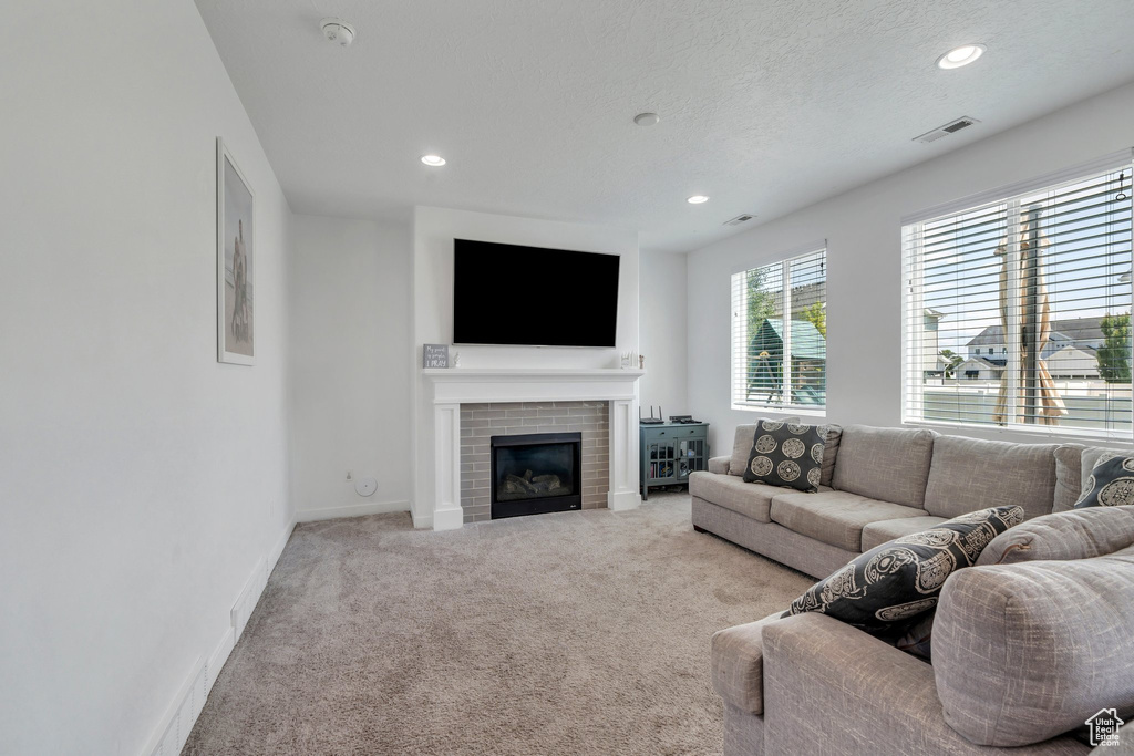 Living room with recessed lighting, carpet, and a brick fireplace