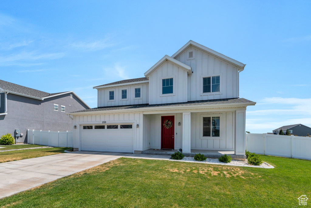 Modern inspired farmhouse with board and batten siding, a porch, driveway, and an attached garage