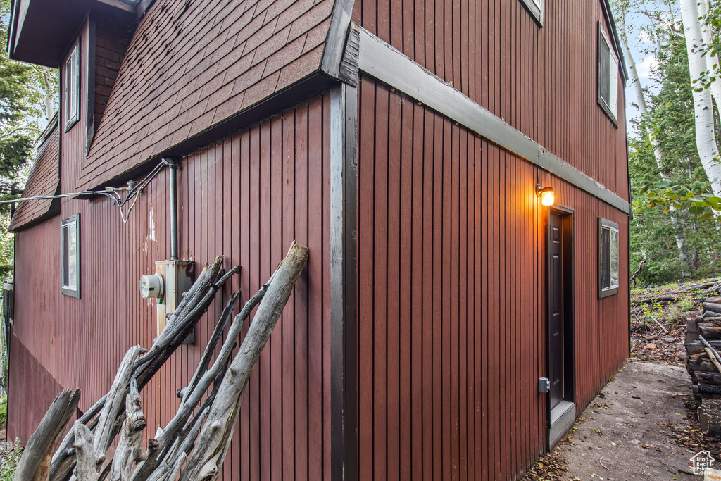 View of property exterior with a shingled roof
