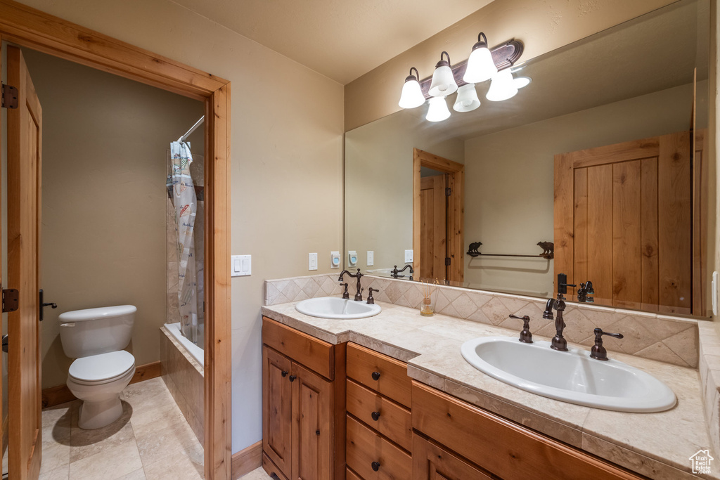 Full bathroom with double vanity and shower / tub combo