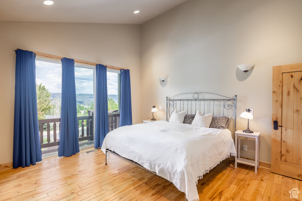 Bedroom featuring access to outside, light wood-style floors, recessed lighting, and lofted ceiling