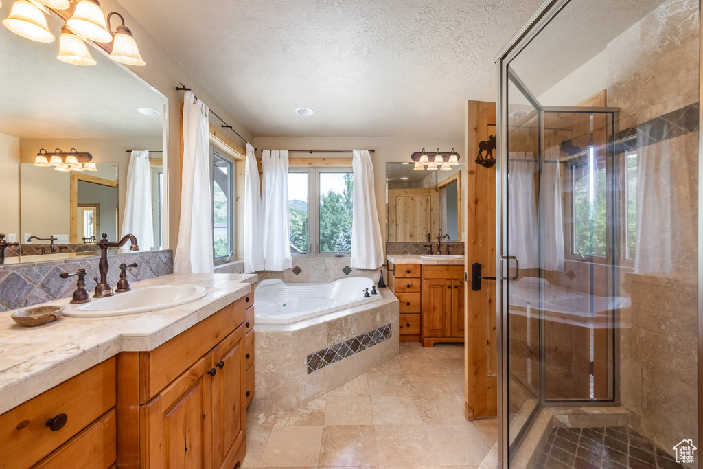 Bathroom with two vanities, a garden tub, a shower stall, tile patterned floors, and recessed lighting