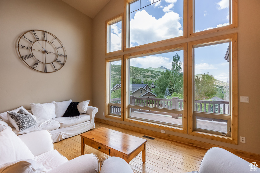 Living room with a mountain view, vaulted ceiling, and hardwood / wood-style floors