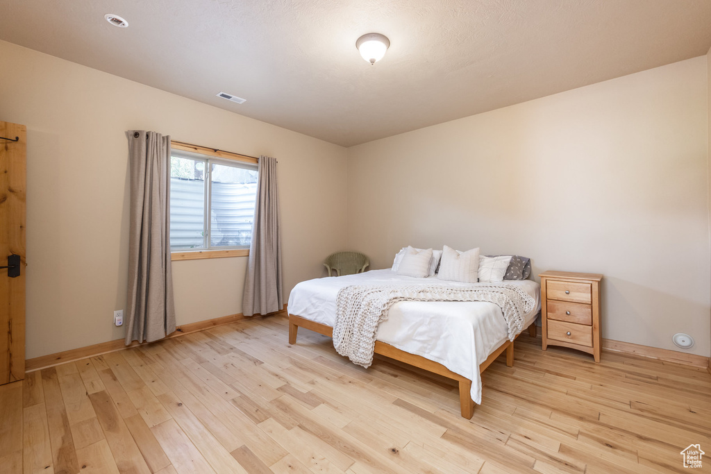 Bedroom with light wood-type flooring and baseboards