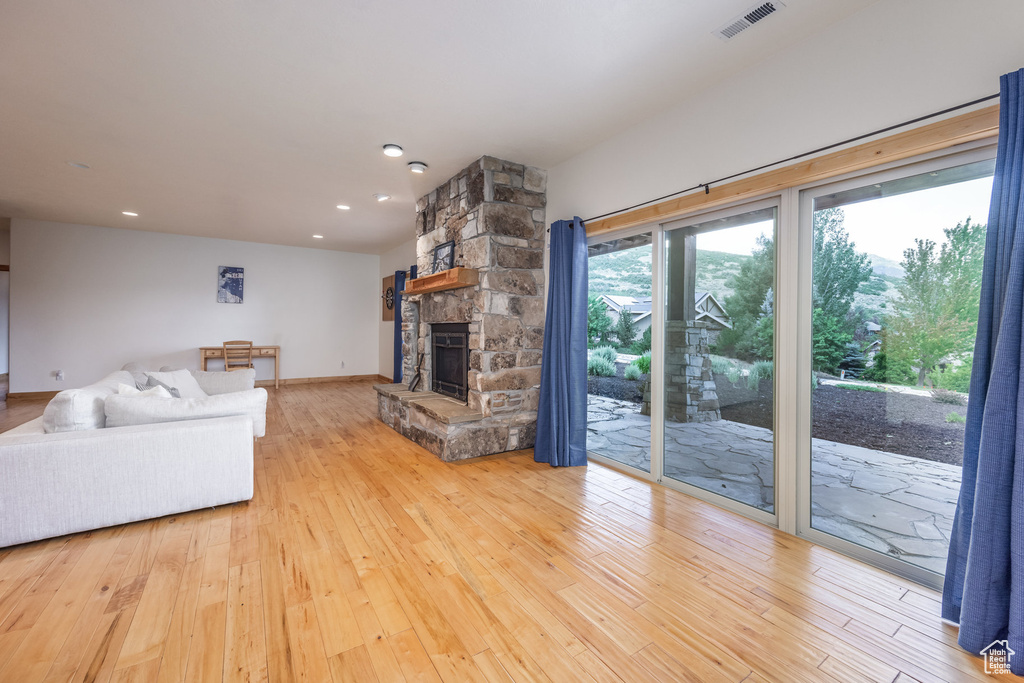 Living room featuring a fireplace, wood-type flooring, and recessed lighting