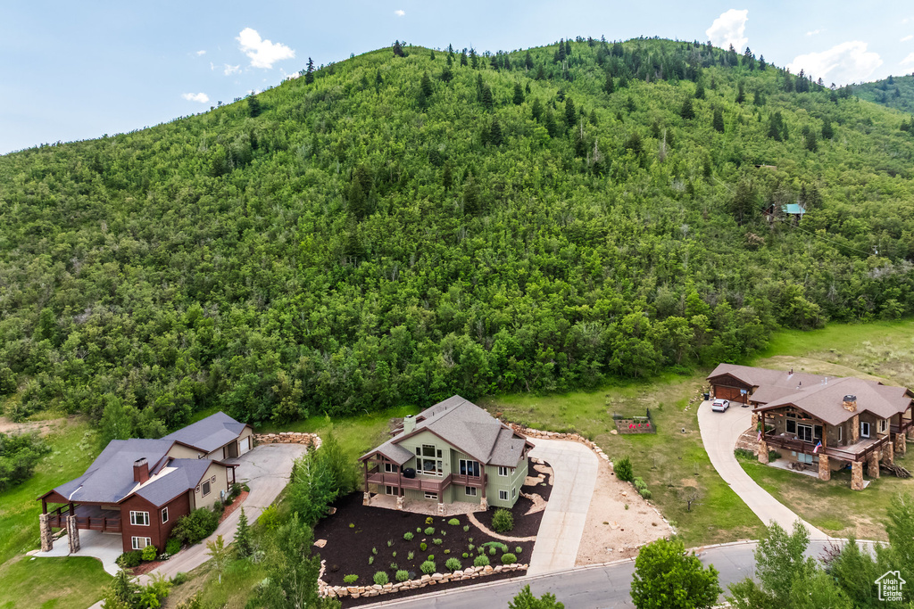 Aerial view of property and surrounding area with a forest