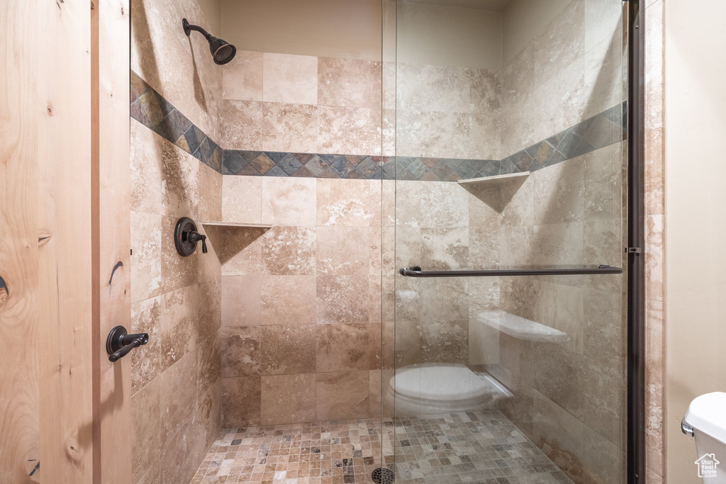 Bathroom featuring toilet and a stall shower