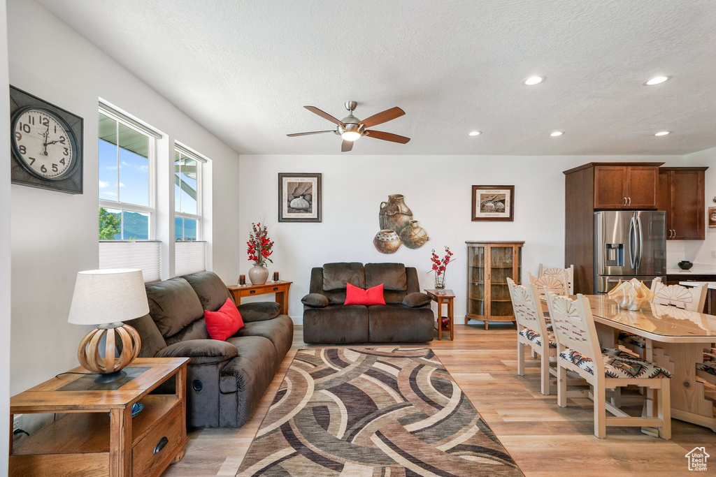 Living area with ceiling fan, light wood-type flooring, recessed lighting, and a textured ceiling
