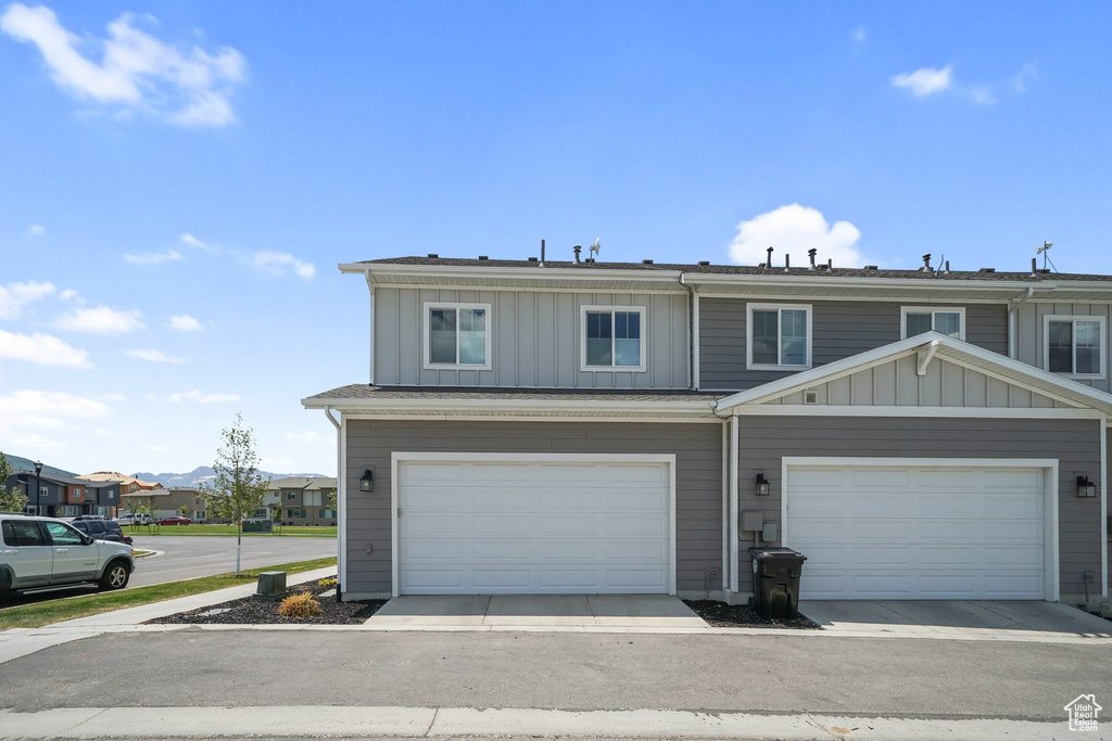 Townhome / multi-family property featuring board and batten siding, a garage, and a residential view