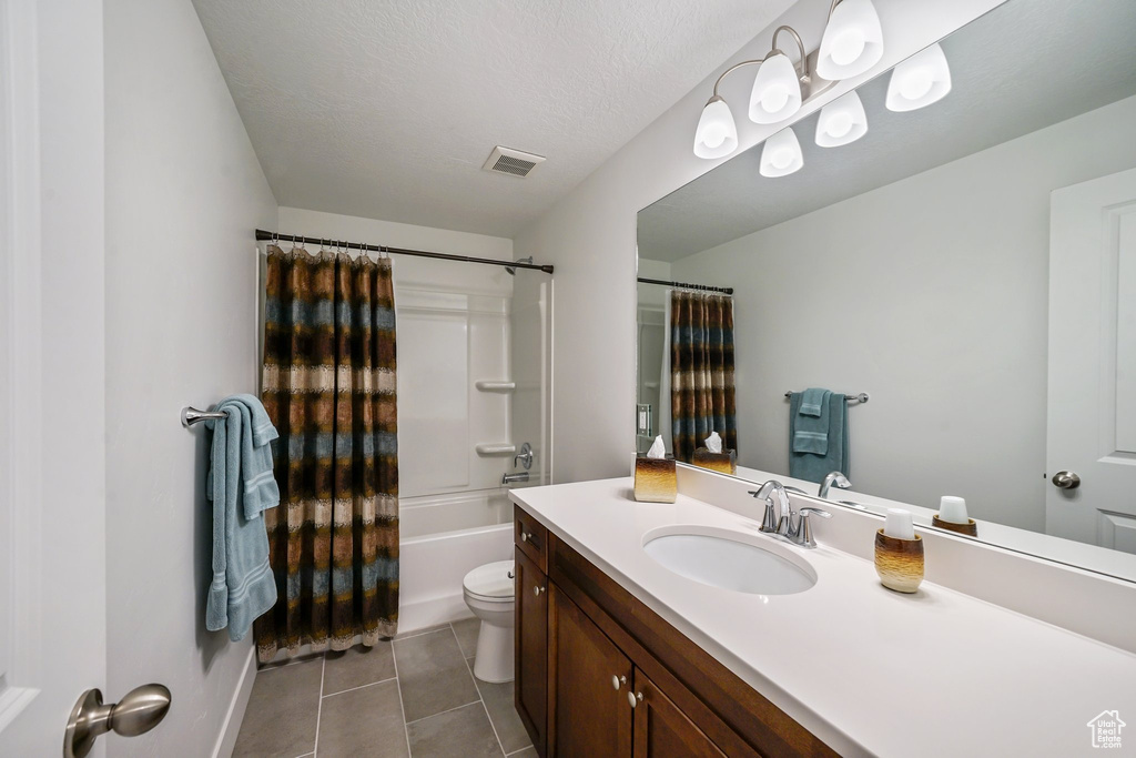 Bathroom featuring vanity, tile patterned flooring, and shower / bathtub combination with curtain