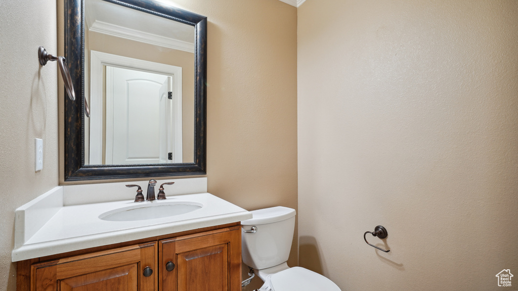 Half bathroom featuring crown molding and vanity