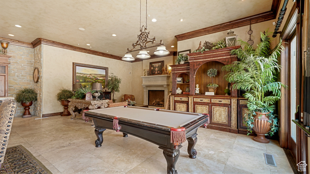 Rec room with ornamental molding, pool table, a fireplace, and recessed lighting