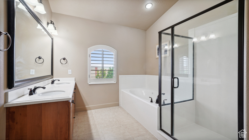 Full bath with vaulted ceiling, double vanity, a garden tub, a stall shower, and tile patterned flooring