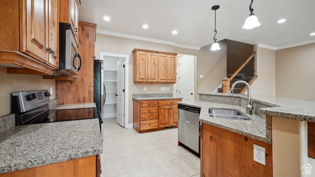 Kitchen featuring stainless steel appliances, crown molding, decorative light fixtures, recessed lighting, and light stone counters