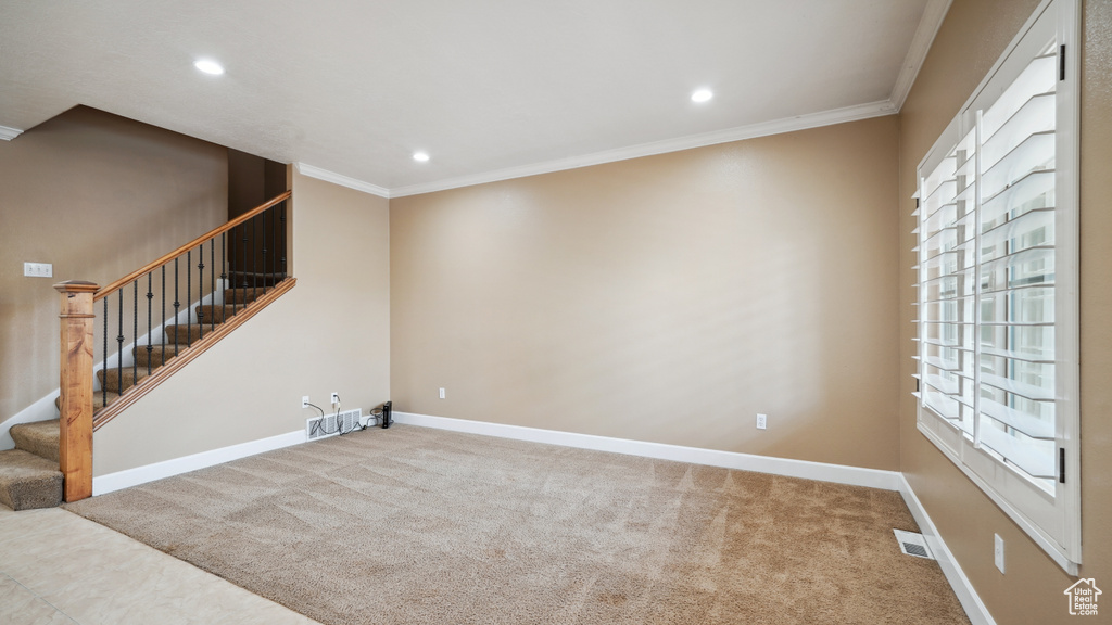 Carpeted empty room with crown molding, stairway, and recessed lighting