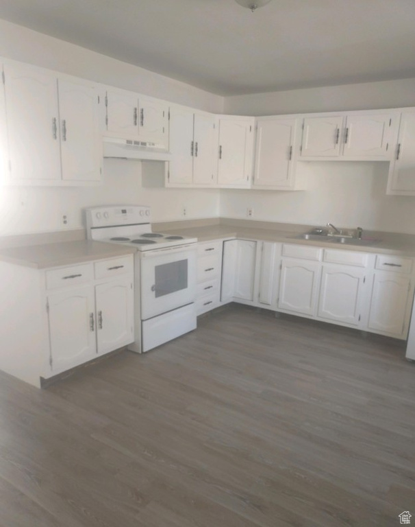 Kitchen with electric stove, ventilation hood, dark wood finished floors, and white cabinetry