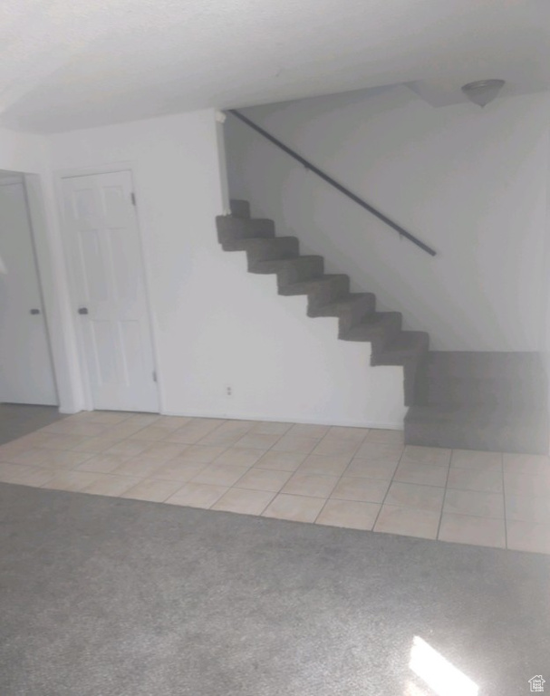 Stairway with carpet and tile patterned flooring
