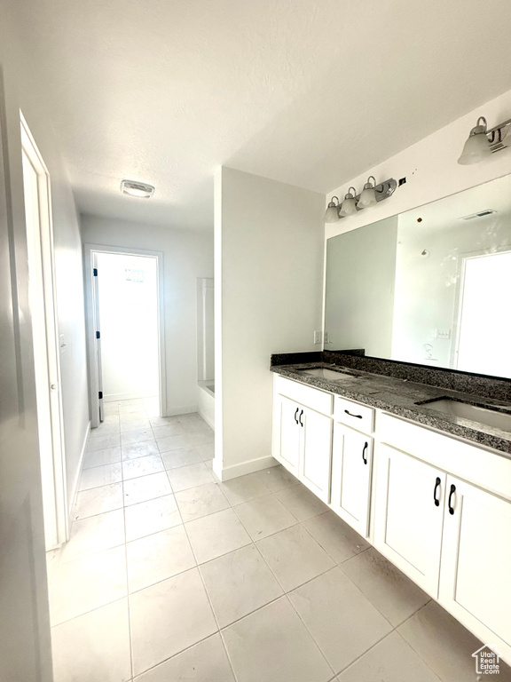 Full bathroom with double vanity, a shower, tile patterned floors, a bath, and a textured ceiling