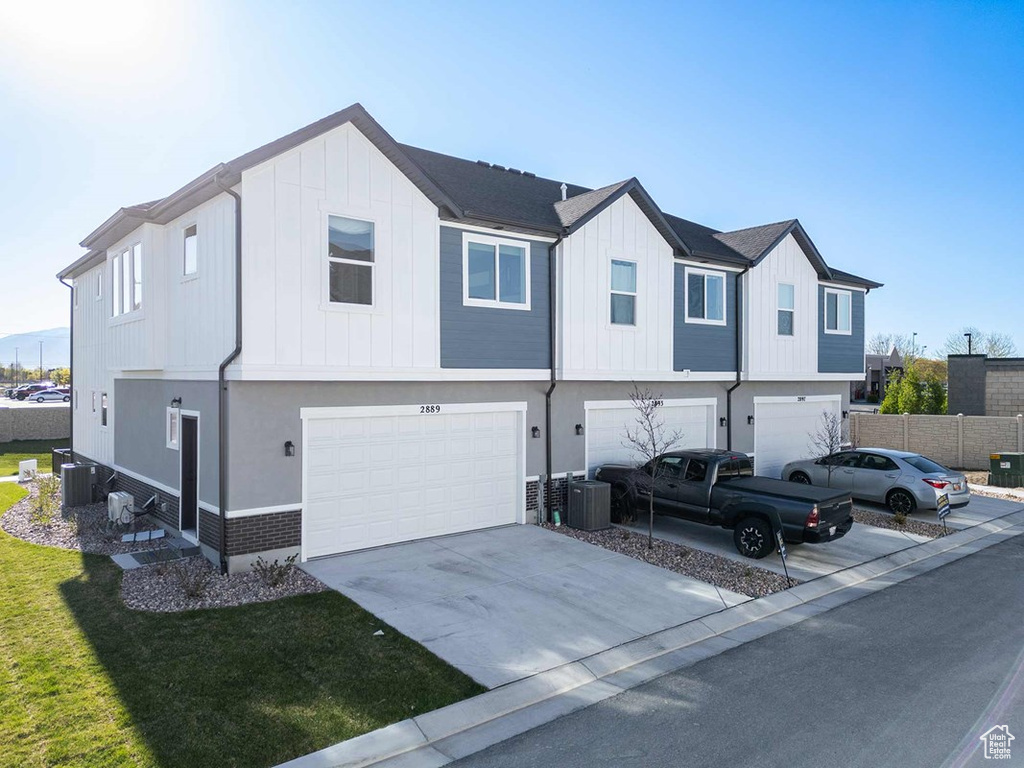 View of front of home with an attached garage, driveway, and board and batten siding