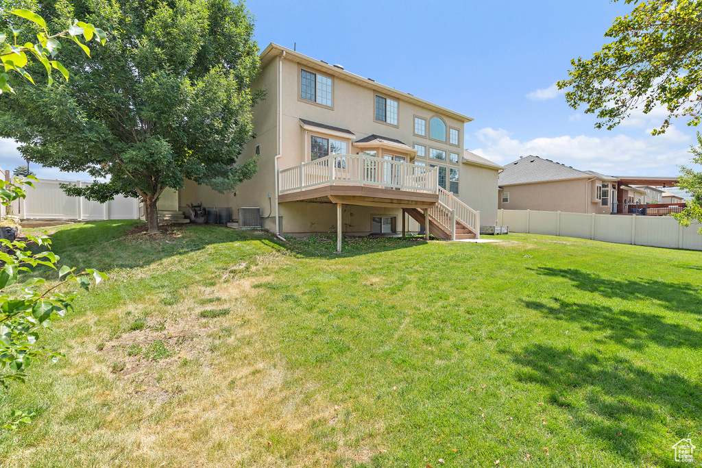Rear view of property featuring stairway, a deck, a fenced backyard, and stucco siding