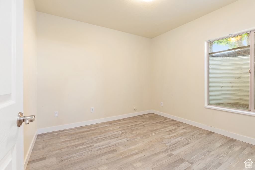 Spare room featuring light wood-type flooring and baseboards